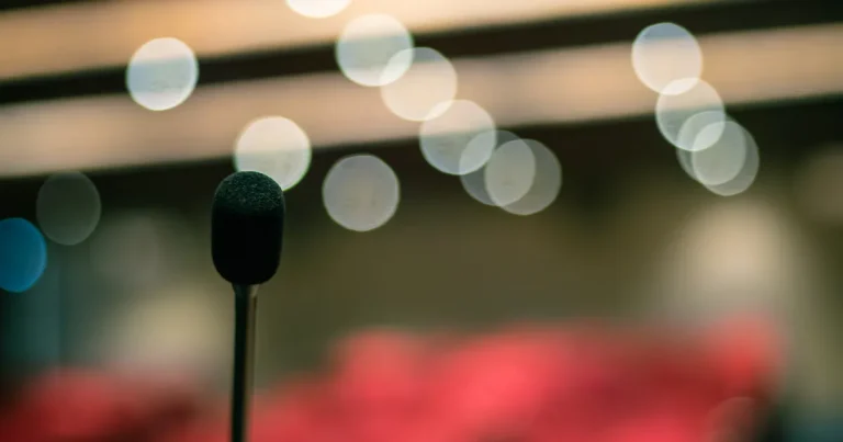 Spotlight Queer Mülheim: Mikrofon vor bunten Bühnenlichtern als Symbolfoto für Poetry, Drag und DJ-Kultur